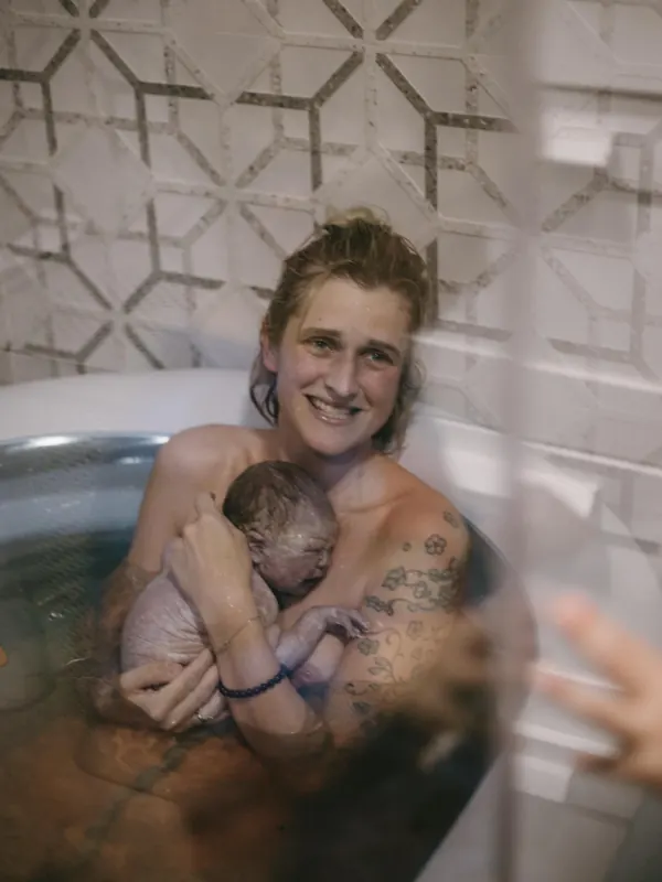 Mama mit Neugeborenem nach der Wassergeburt — selbstbestimmte Geburt