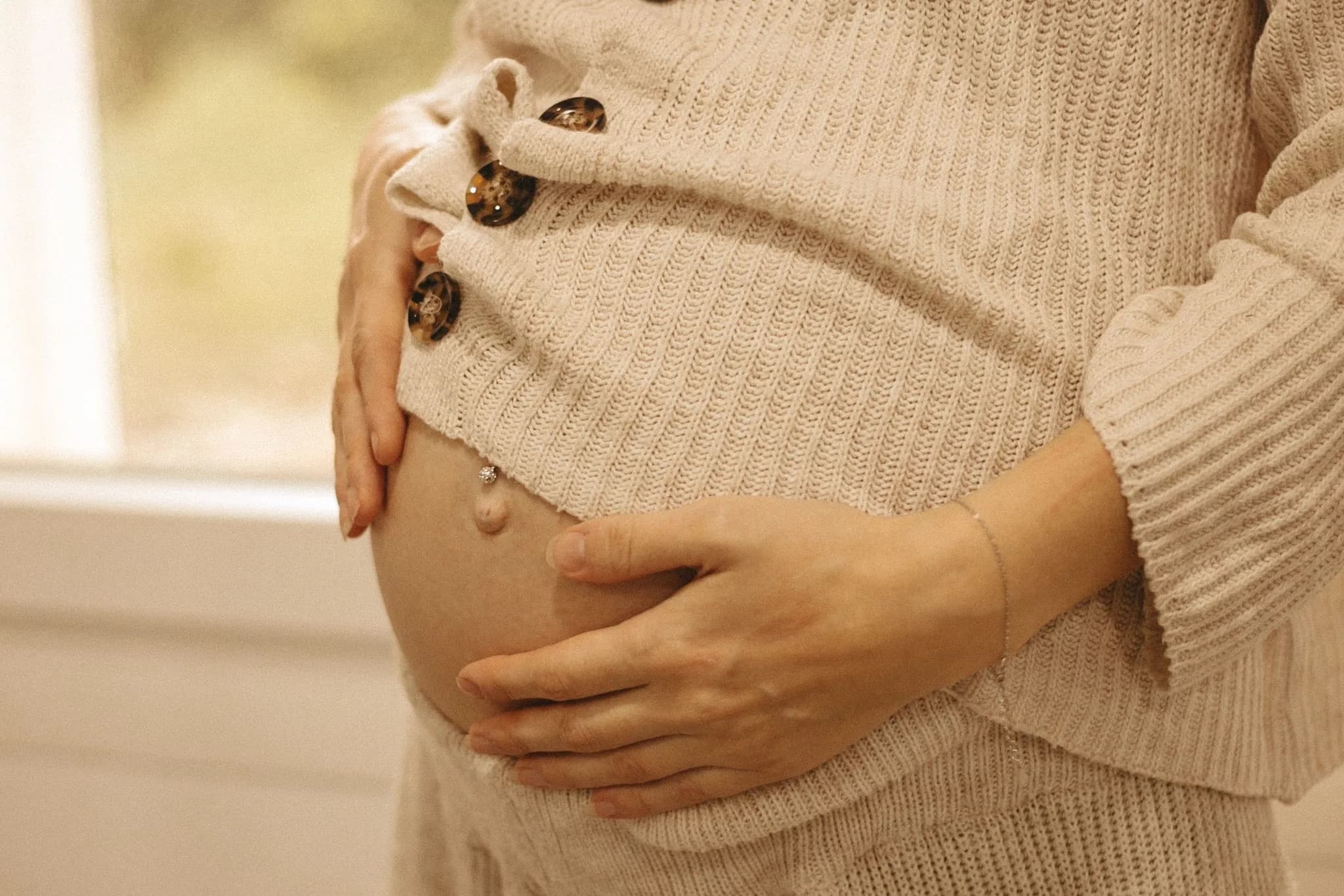 Schwangere Mama hält liebevoll ihren Babybauch — SULIA Akademie Verbundenheit